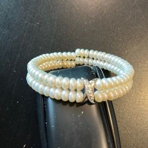 Elasticized pearl bracelet with rhinestone embellishment in a silver “x”